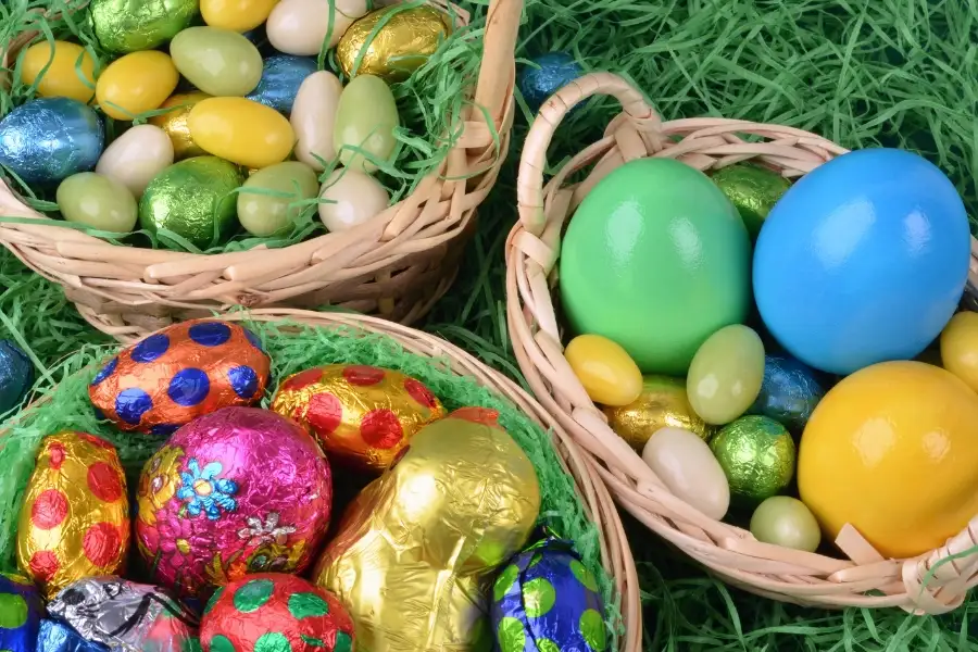 Three Easter baskets filled with chocolate eggs and faux grass. This image is for the blog post titled, "Easter Activities for Toddlers." 