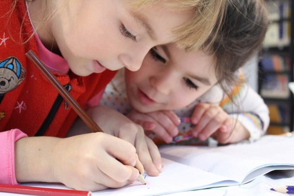 Two children coloring a Mother's Day gift after reading Primary Beginnings blog about craft ideas for children.