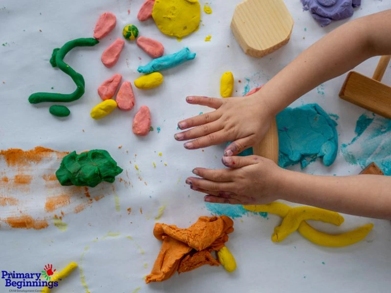 Hands rolling out play dough for the blog post titled "Easter Activities for Toddlers."