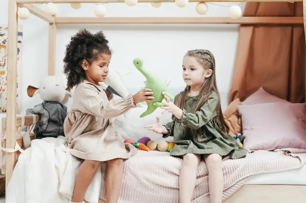 Picture of two preschool students sharing a dinosaur toy after a lesson on teaching sharing to preschoolers