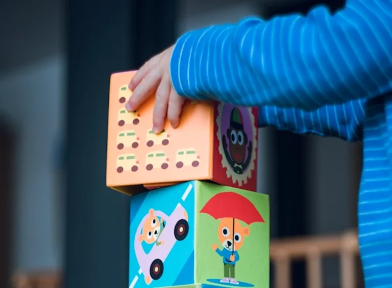 toddler care - child stacking colorful learning blocks